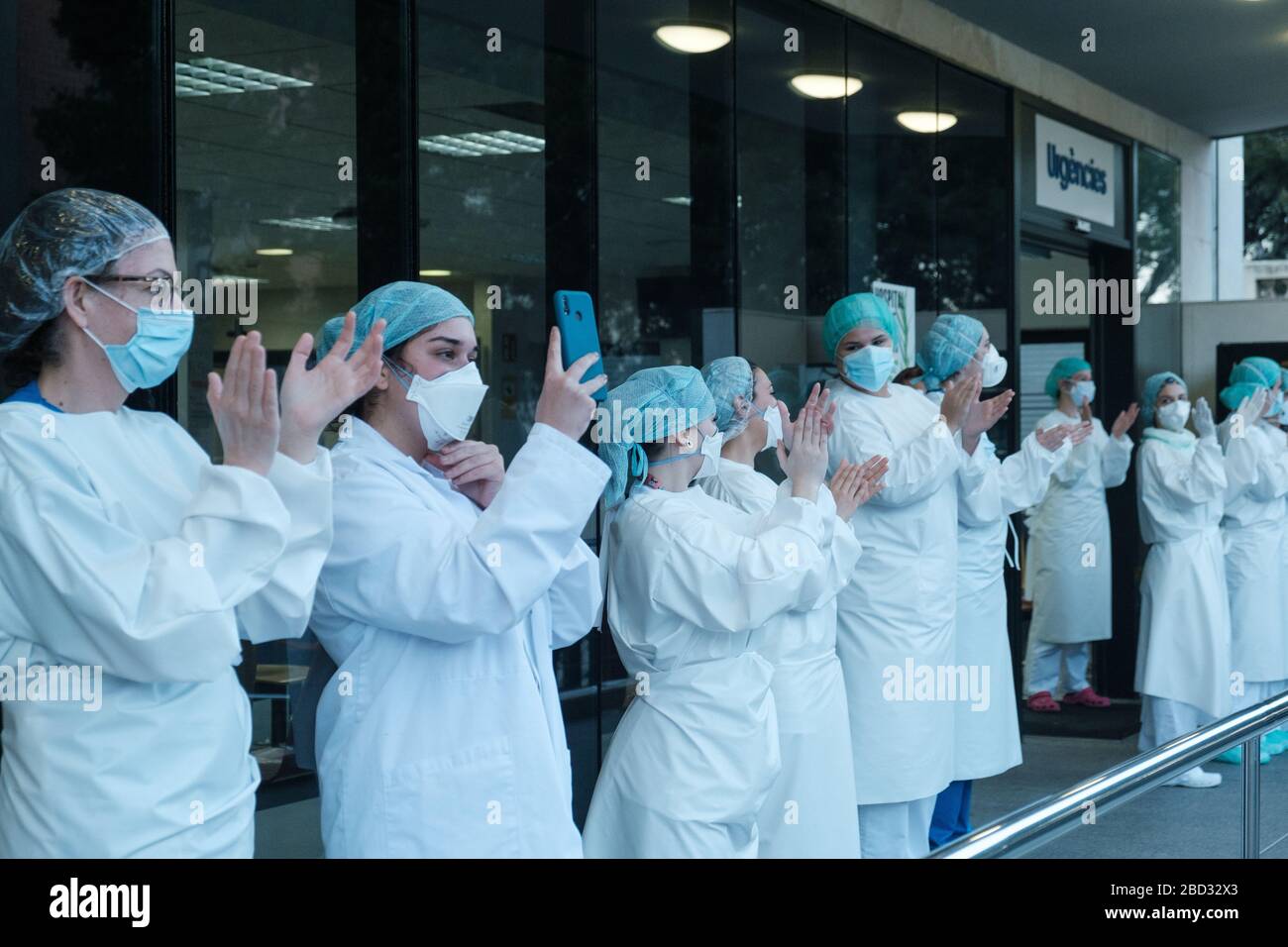 Un gruppo di medici e personale sanitario della clinica ospedaliera applaude coloro che mostrano gratitudine nei loro confronti durante la crisi del coronavirus. La clinica ospedaliera di Barcellona è uno dei principali centri in cui Covid19 è combattuto in Spagna. Poiché lo stato di allarme è stato decretato in tutto il paese a causa dell'aumento delle infezioni da coronavirus, sono state diagnosticate più di 120,000 persone e 12,000 sono morte a causa del virus. Foto Stock