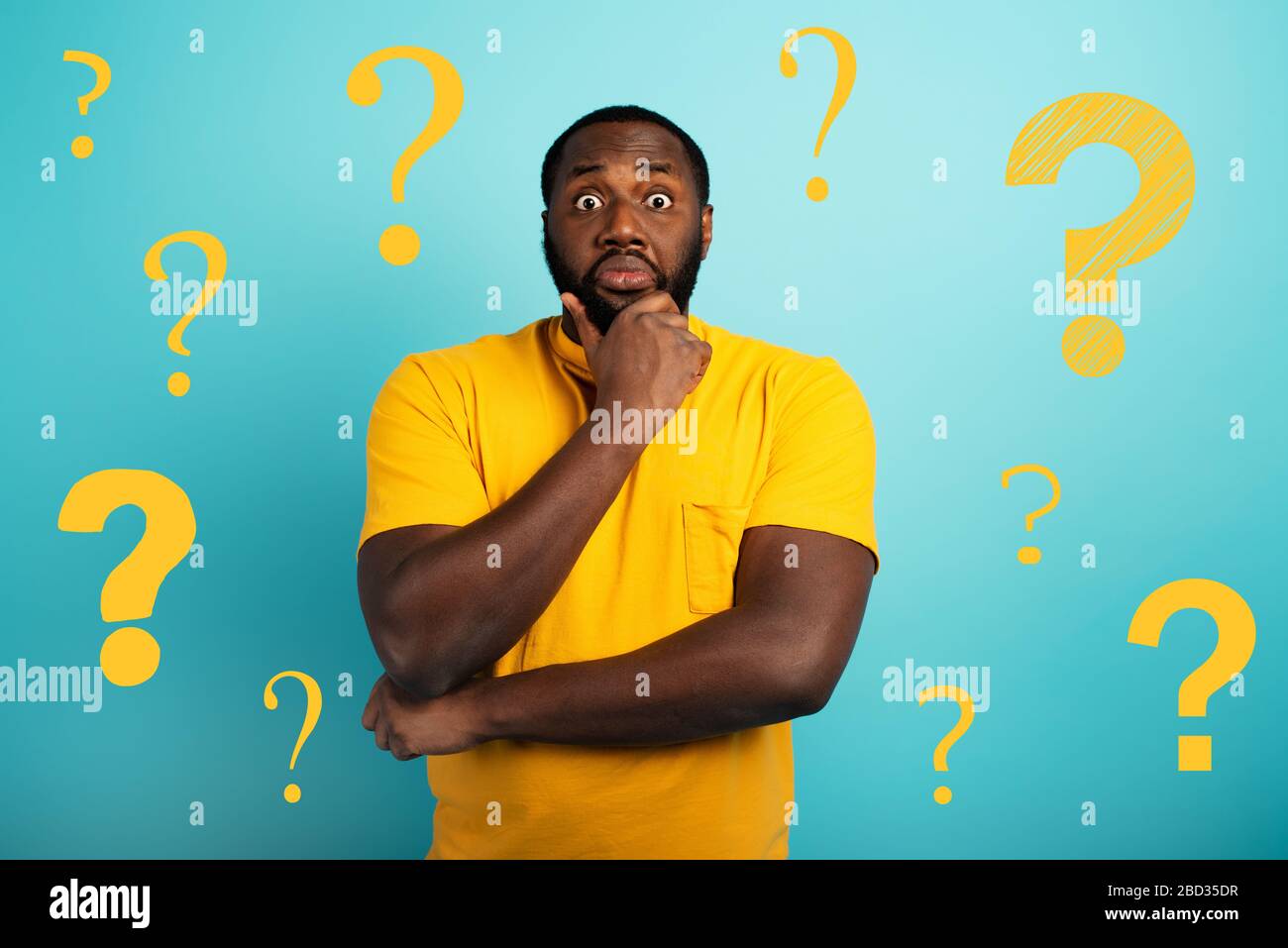 Confondere e pensieroso espressione di un ragazzo con molte domande . ciano sfondo colorato Foto Stock