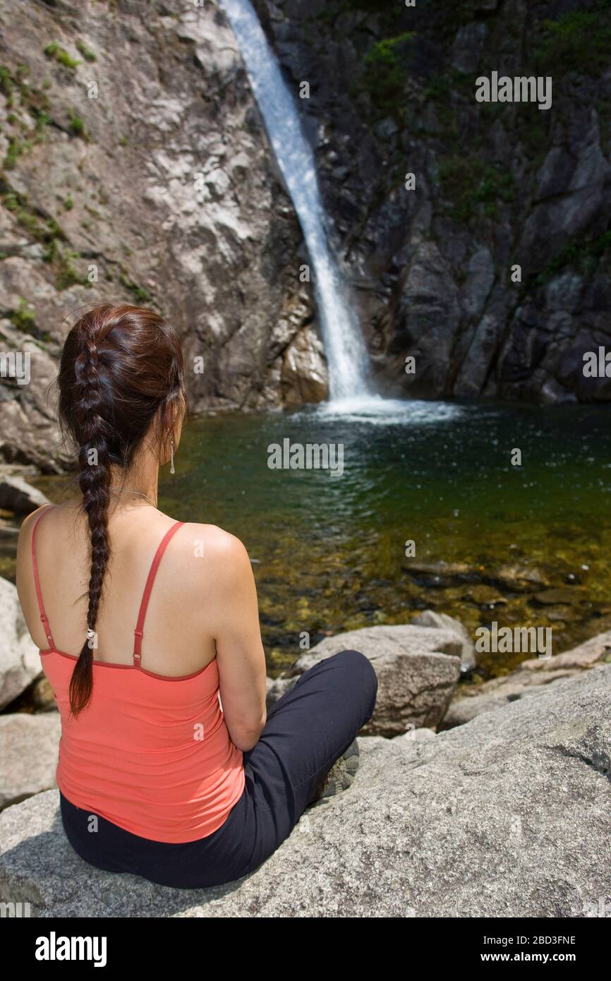 Donna seduta accanto ad una cascata al parco nazionale Seroksan Foto Stock