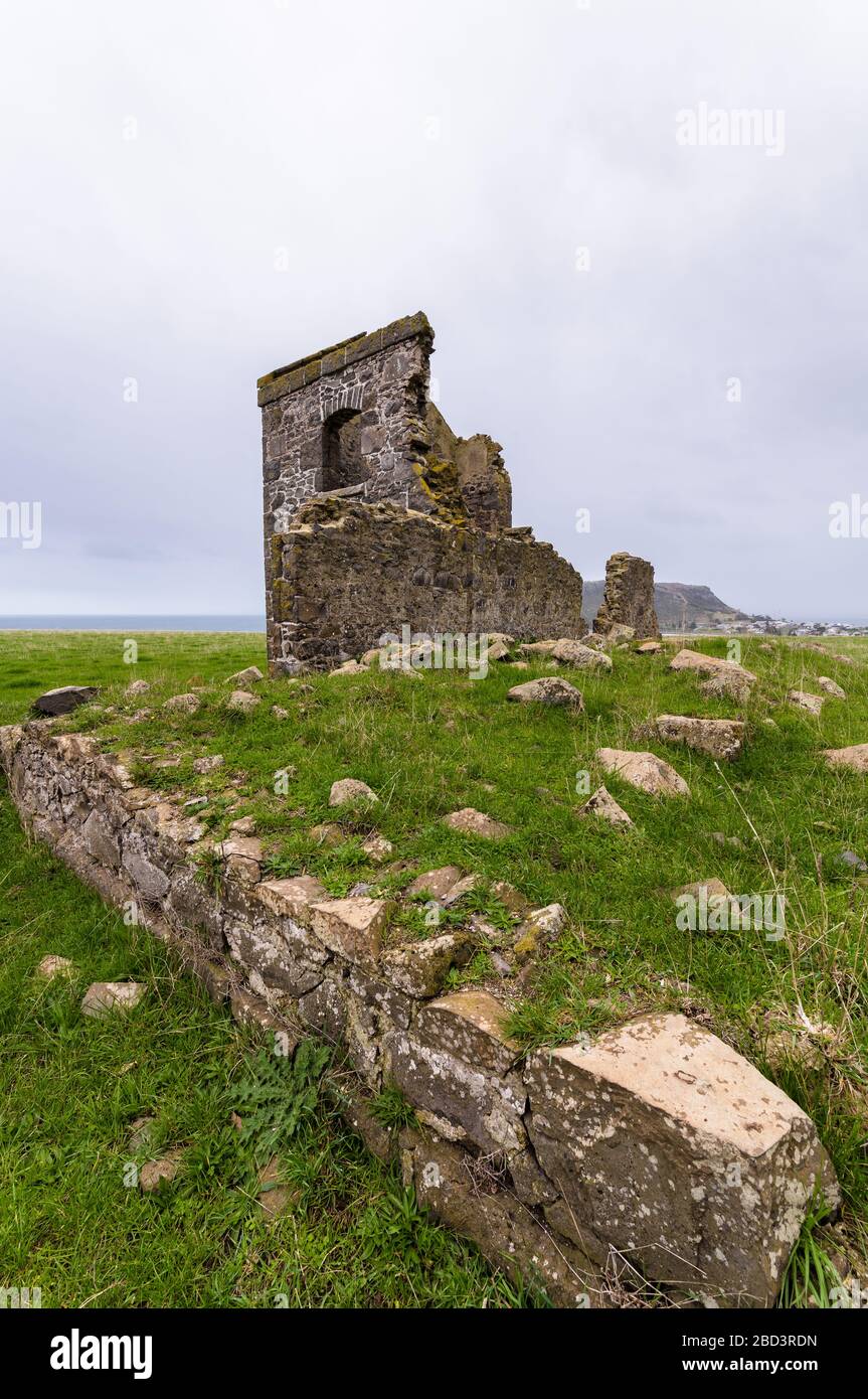 Rovine di pietra del vecchio patrimonio di Highfield Village nella città di Stanley in Tasmania visto da una prospettiva bassa su un cavolo erboso Foto Stock