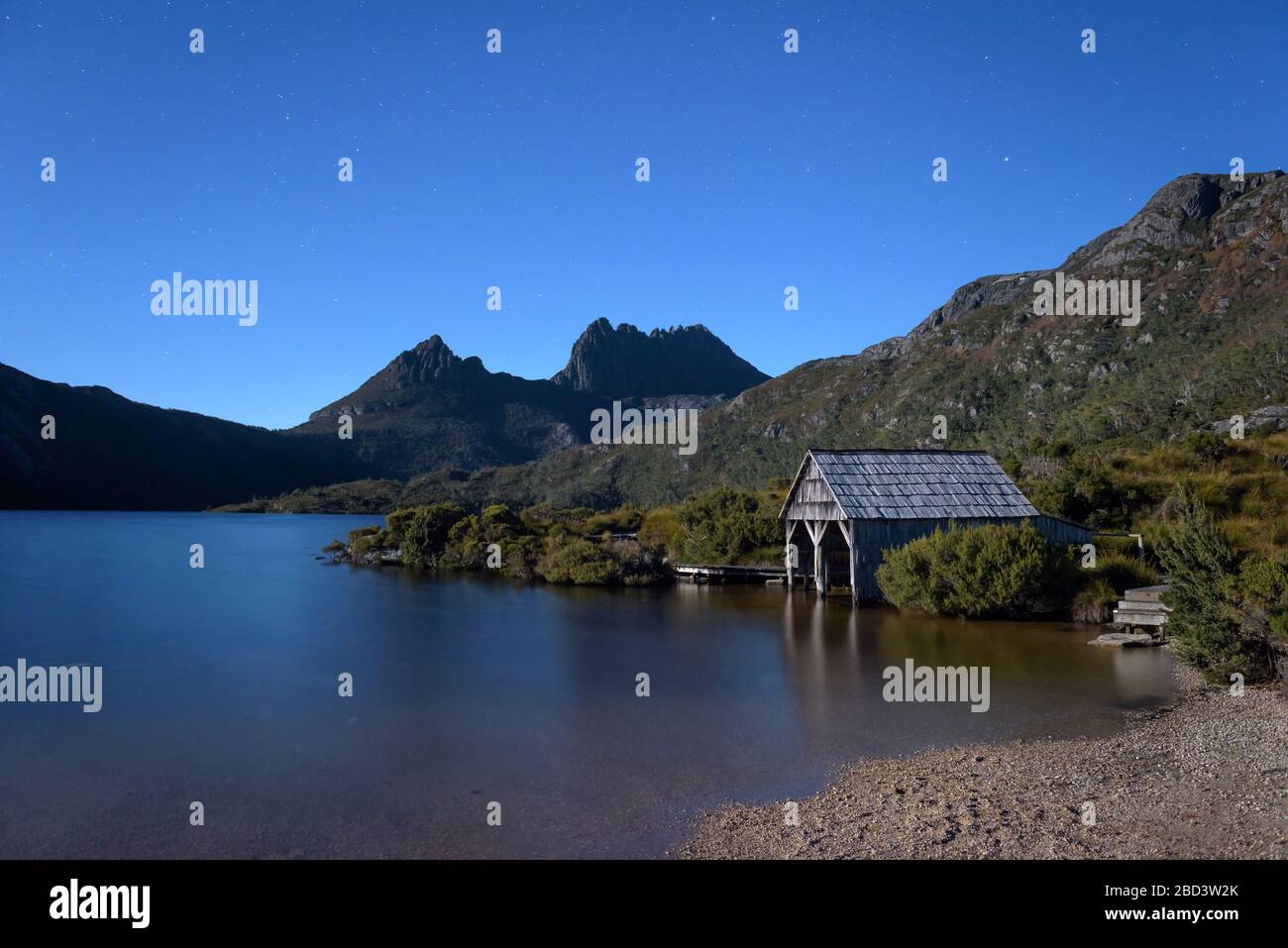 Le stelle blu iniziano a ricoprire l'iconico Lago dove e si stagliano, conducendo alle due vette del Monte Cradle su un cielo notturno limpido in Tasmania. Foto Stock