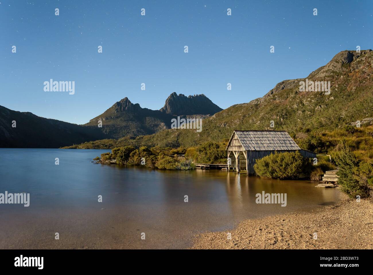 Le stelle blu iniziano a ricoprire l'iconico Lago dove e si stagliano, conducendo alle due vette del Monte Cradle su un cielo notturno limpido in Tasmania. Foto Stock