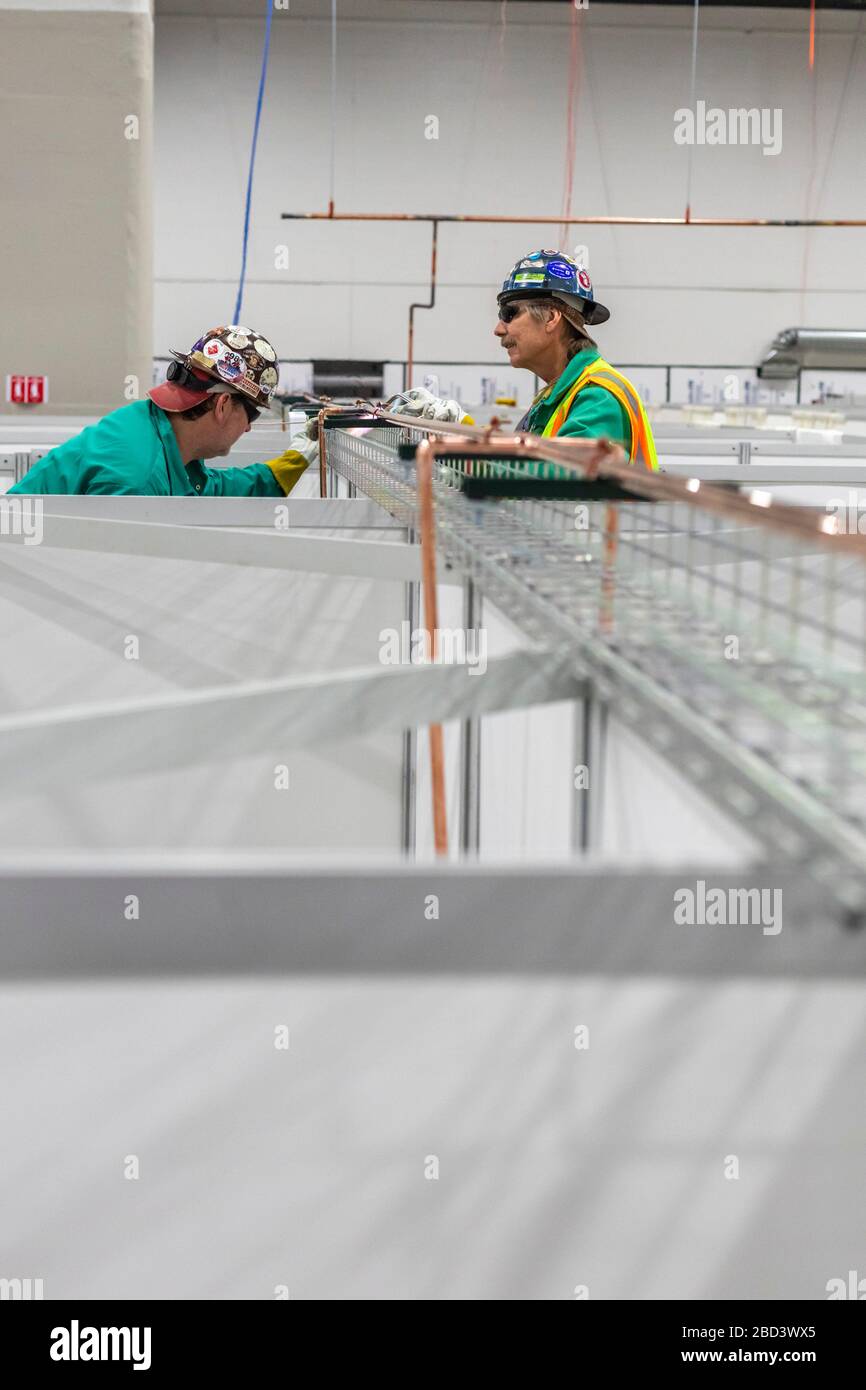 Detroit, Michigan, Stati Uniti. 6 Aprile 2020. I lavoratori costruiscono un ospedale di emergenza presso il centro congressi TCF. L'ospedale a 1,000 letti si occuperà dei pazienti con Covid-19. I Pipefitters installano un sistema di alimentazione dell'ossigeno. Credit: Jim West/Alamy Live News Foto Stock