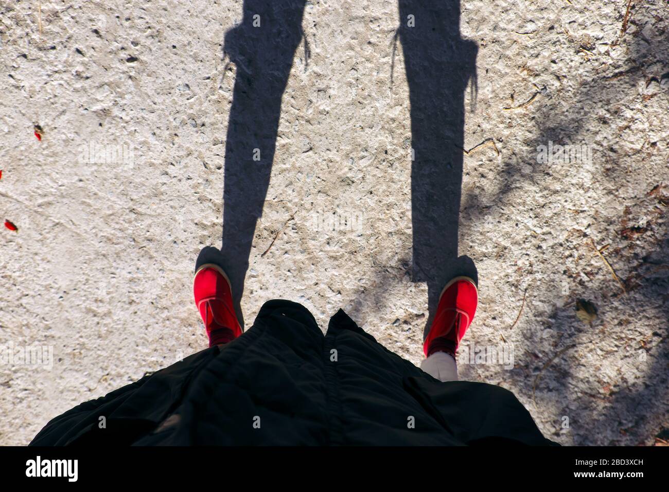 Vista spettacolare quando la fotografa femminile si fa il selfie al mattino presto, ombra divertente da Jean strappato al ginocchio e scarpe rosse da persone in piedi Foto Stock