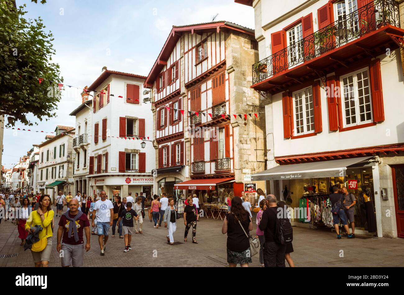Saint Jean de Luz, Paesi Baschi francesi, Francia - Luglio 13th, 2019 : La Gente passa davanti agli edifici tradizionali nel centro storico di Saint Jean de Lu Foto Stock