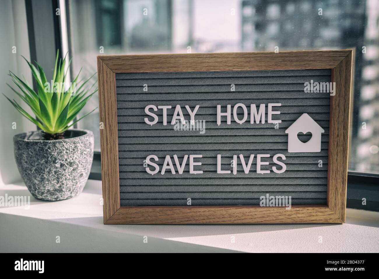 STAY HOME SAVE LIVES Stay home auto quarantena COVID-19 Coronavirus testo messaggio segno per la consapevolezza di distanza sociale. COVID-19 stare a casa sfondo finestra. Appiattire la curva. Foto Stock