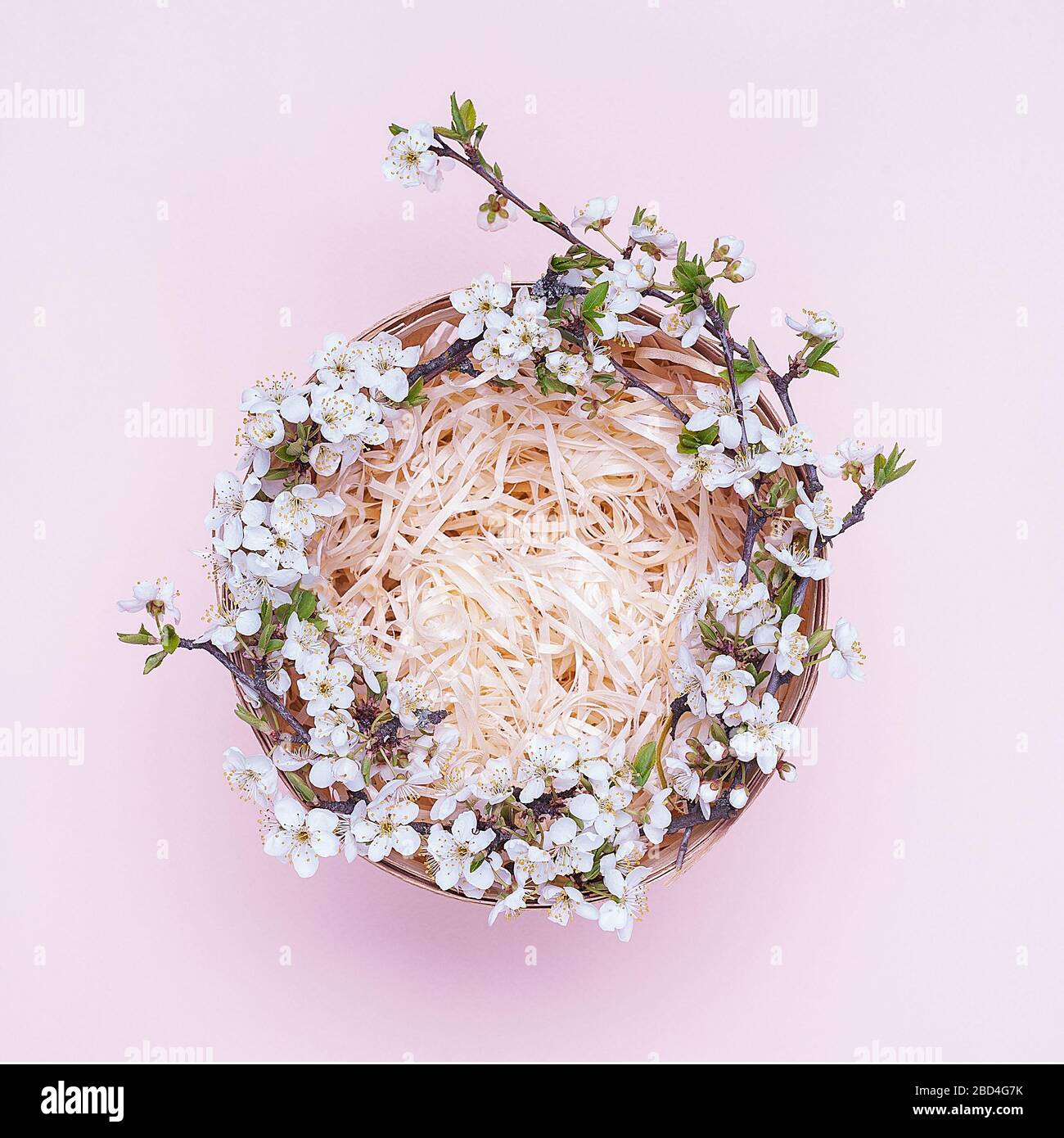 Cesto vuoto con una corona di fiori bianchi su sfondo rosa. Posizionare per il testo Flatley. Vista dall'alto Fotografia Square.Flatley. Vista dall'alto. L'oggetto in Foto Stock
