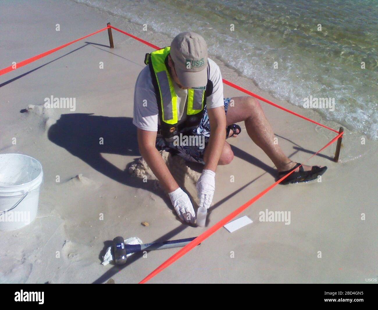 U.S. Geological Survey (USGS) scienziati hanno raccolto dati ambientali e campioni nelle aree costiere colpite dalla fuoriuscita di petrolio di Deepwater Horizon nel Golfo del Messico nel 2010. Campioni di acqua, sedimenti, invertebrati bentici, e microrganismi sono stati raccolti dagli USGS in spiaggia, isola di barriera, e ambienti di zone umide del Golfo del Messico litoranea prima e dopo che il prodotto associato al petrolio è arrivato sulla riva. In questa foto, un nucleo di sedimenti è raccolto a Gulf Island vicino Navarra, Florida. Le analisi USGS del sedimento saranno utilizzate per identificare i cambiamenti chimici e biologici che possono verificarsi Foto Stock