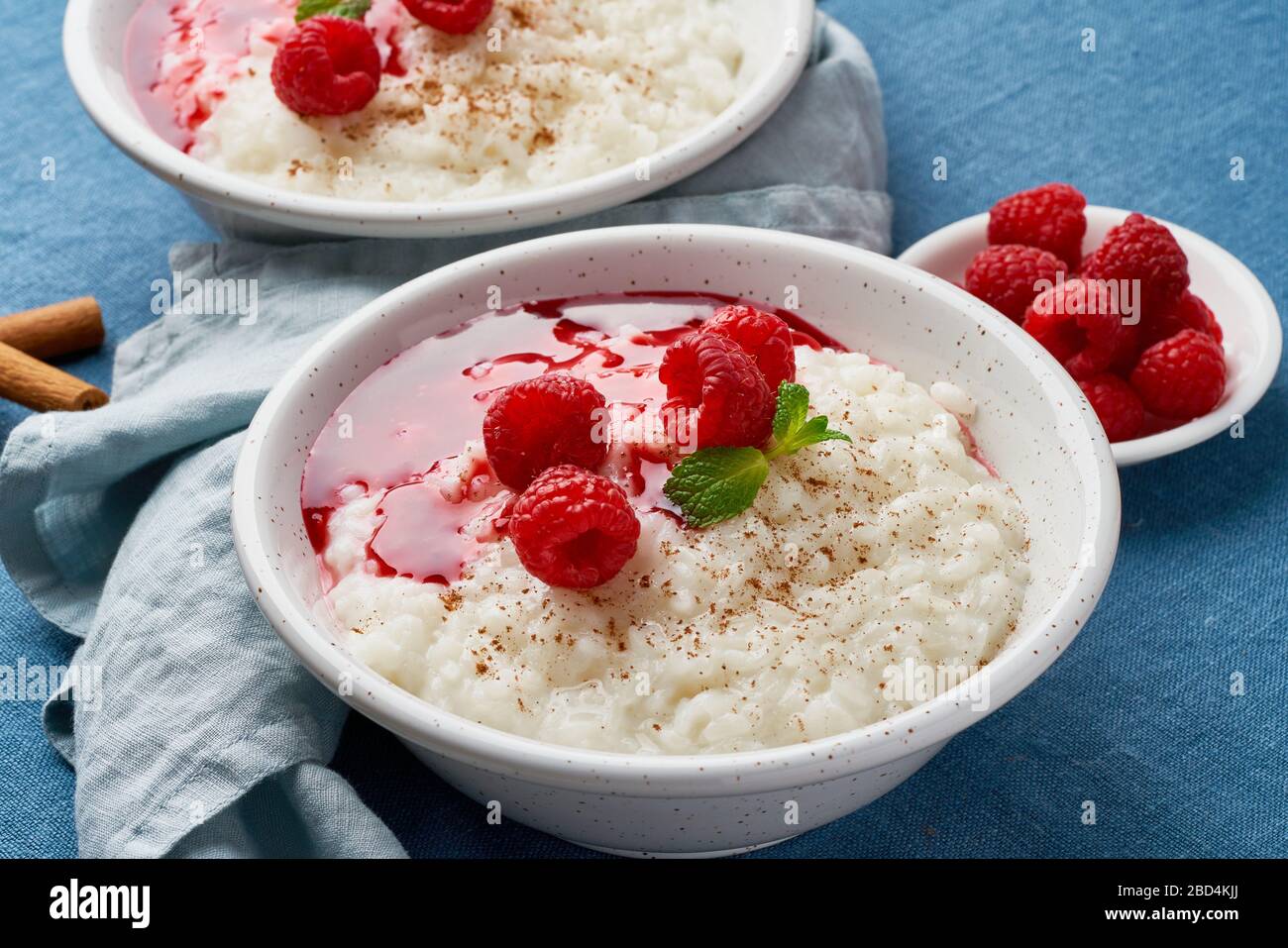 Budino di riso. Dessert francese di riso al latte con lamponi e mirtilli. Sfondo scuro, vista laterale Foto Stock