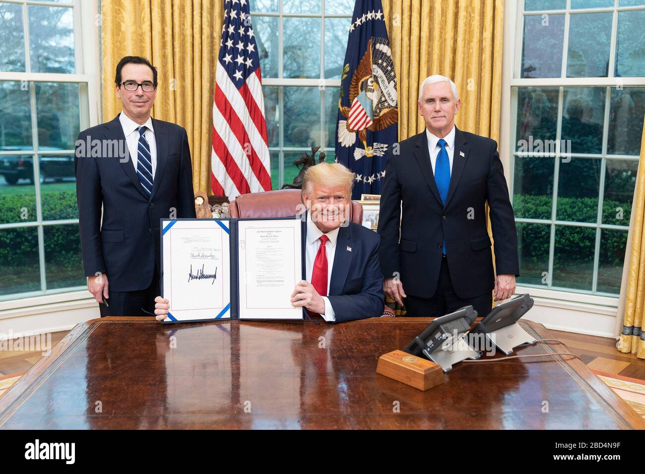 Il residente Donald J. Trump è Unito dal Vice Presidente Mike Pence e dal Segretario del Tesoro Steven Mnuchin come firma S.R. 6201, le famiglie First Coronavirus Response Act, Mercoledì, 18 marzo 2020, presso l'Ufficio ovale della Casa Bianca. Foto Stock