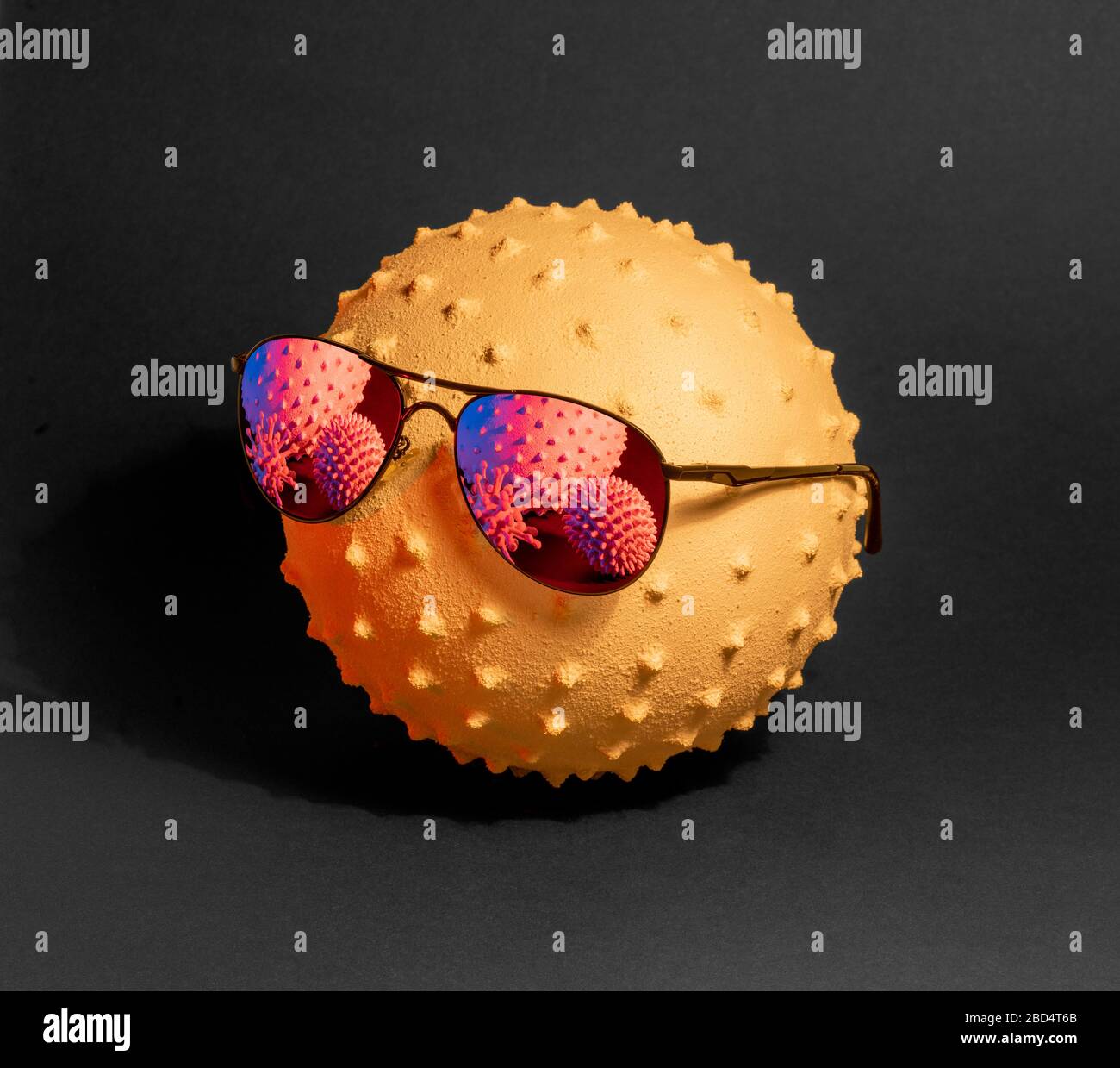 colpo di primo piano che mostra un virus simbolico indossando occhiali da sole in scuro schiena Foto Stock