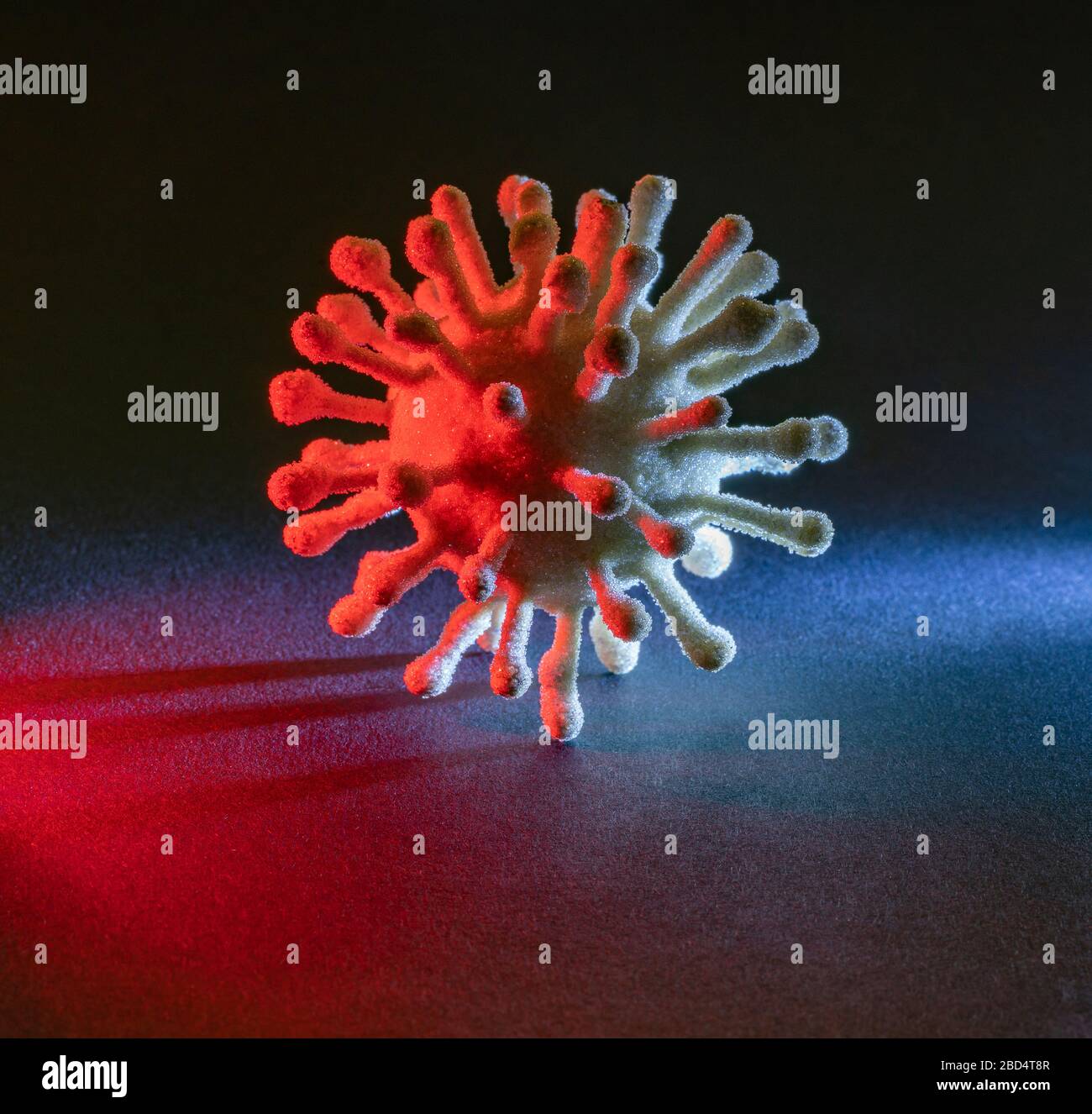 immagine di un colorato virus simbolico illuminato in scuro retro Foto Stock