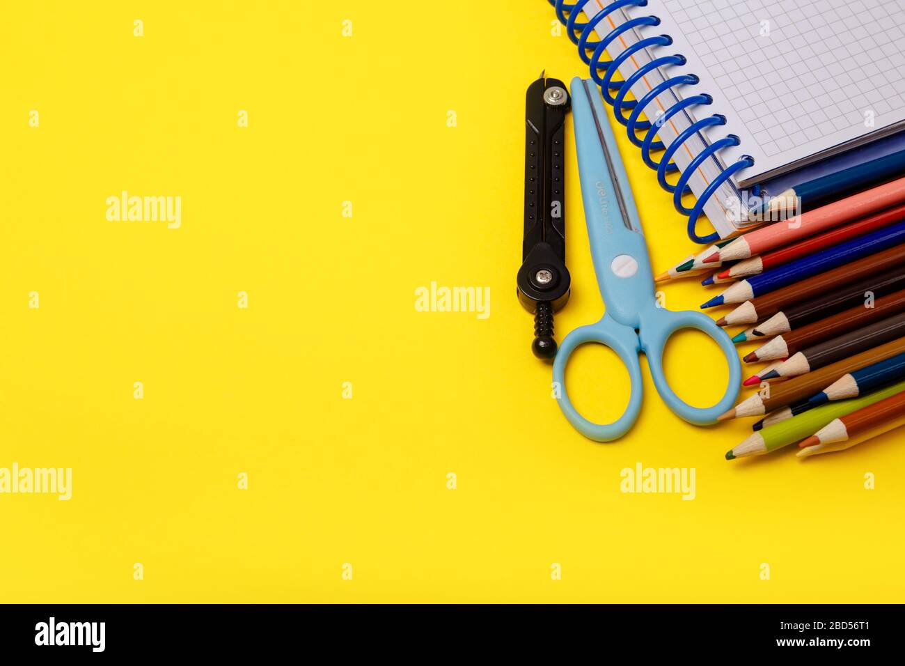 La scuola colorata fornisce il bordo sopra un fondo di carta fiancheggiato. Il concetto di istruzione, studio, apprendimento, elearning. Vista dall'alto. Torna al concetto di scuola Foto Stock