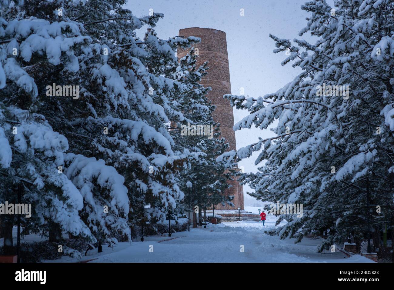 Turisti locali a piedi alla torre Burana in Kirghizistan in inverno neve Foto Stock