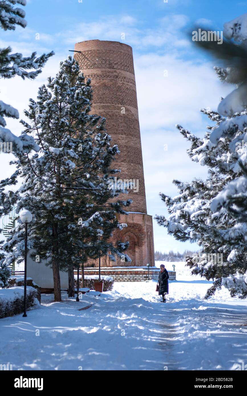 Turisti locali a piedi alla torre Burana in Kirghizistan in inverno neve Foto Stock