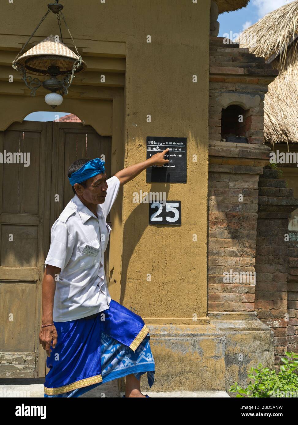 dh House compound building BALI INDONESIA abbigliamento tradizionale Guida turistica che spiega l'escursione Foto Stock