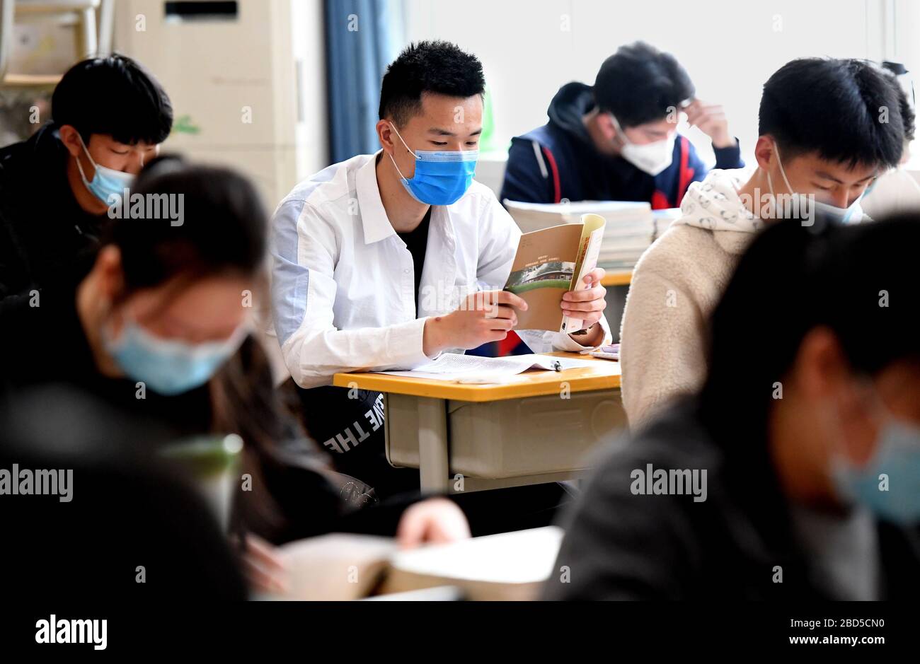Zhengzhou, Cina. 7 Aprile 2020. Gli studenti hanno letto il pamphlet sul romanzo prevenzione dell'epidemia di coronavirus alla scuola media No. 9 a Zhengzhou, Cina centrale, 7 aprile 2020. Gli studenti dell'ultimo anno della scuola superiore sono tornati a scuola martedì a Henan. Credit: Li An/Xinhua/Alamy Live News Foto Stock
