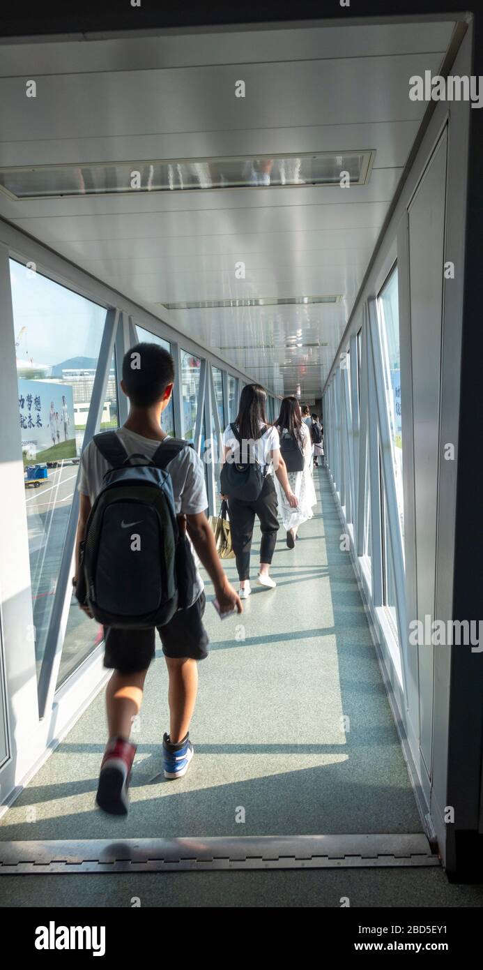 Passeggeri a bordo aereo attraverso passerella, Hangzhou aeroporto, Cina Foto Stock