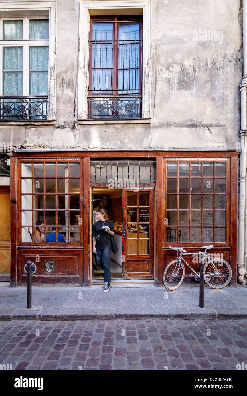 Cliente che lascia il Circus Bakery - un panificio parigino alla moda nel quartiere Latino specializzato in dolci alla cannella, Parigi, Ile-de-France, Francia Foto Stock