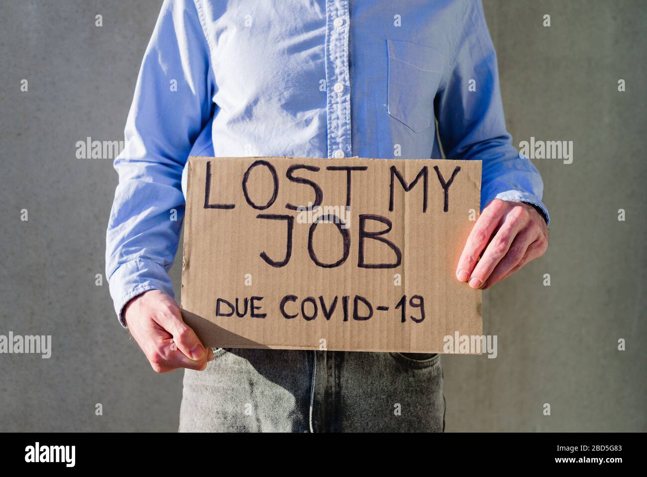 Uomo lavoratore in ufficio in camicia blu con segno di cartone PERSO LAVORO. Senza lavoro, concetto di disoccupazione dovuta a 19. Chiedere soldi Foto Stock