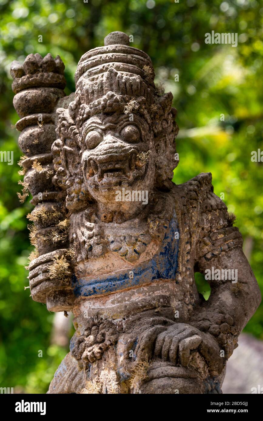 Primo piano verticale di una statua custode del cancello che adorna un tempio a Bali, Indonesia. Foto Stock