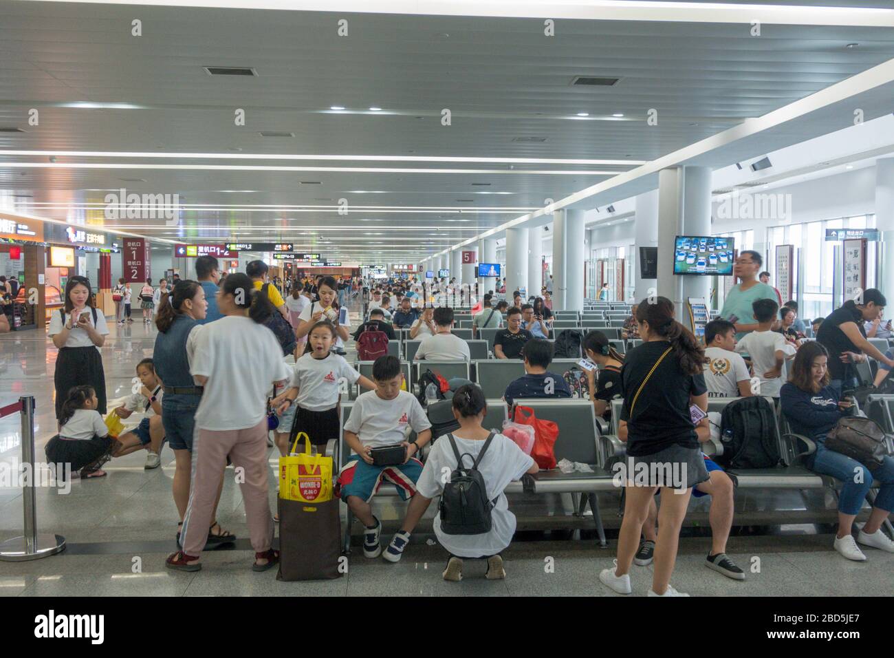 Passeggeri in attesa di salire a bordo, sala partenze, aeroporto di Quanzhou, Cina Foto Stock