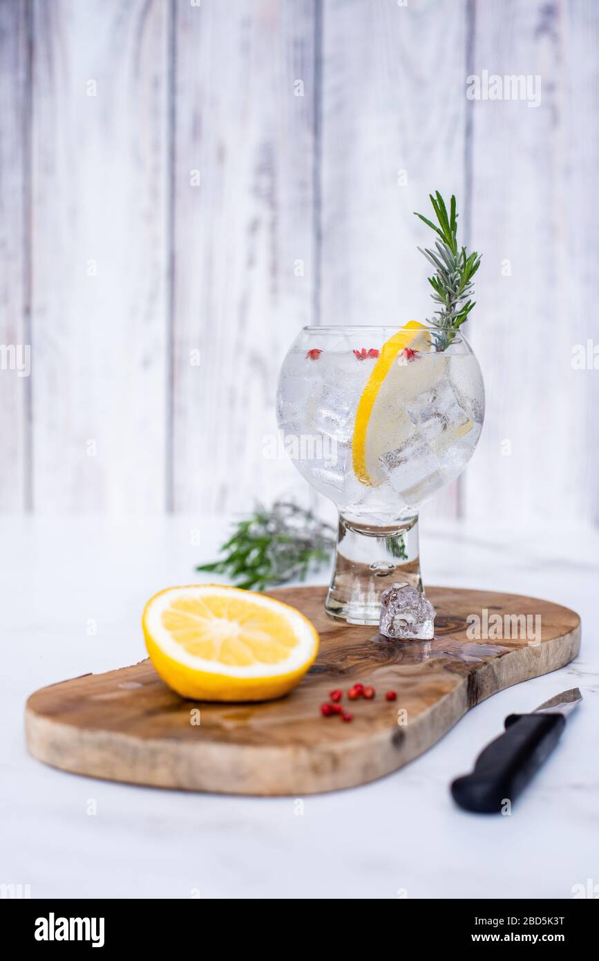 Cocktail Cold Gin & Tonic con contorno al limone su tagliere in legno Foto  stock - Alamy