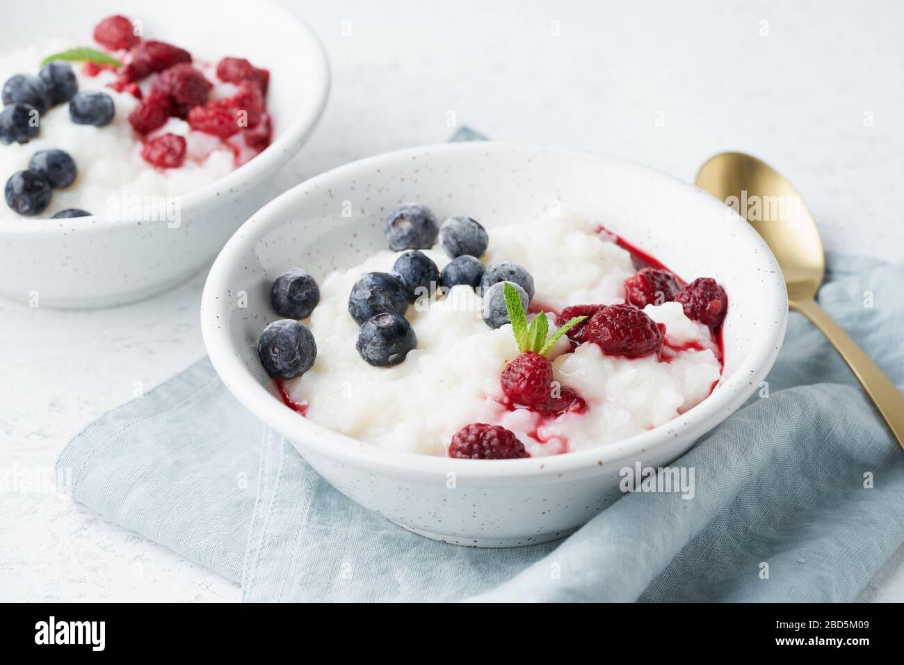 Budino di riso, vista laterale. Dieta sana Vegan colazione con latte di cocco, mirtillo, Foto Stock