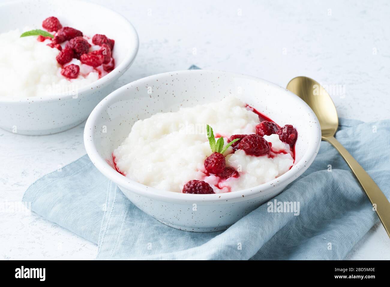 Budino di riso, vista laterale. Sana colazione vegetariana con latte di cocco, lampone, scandinavo Foto Stock