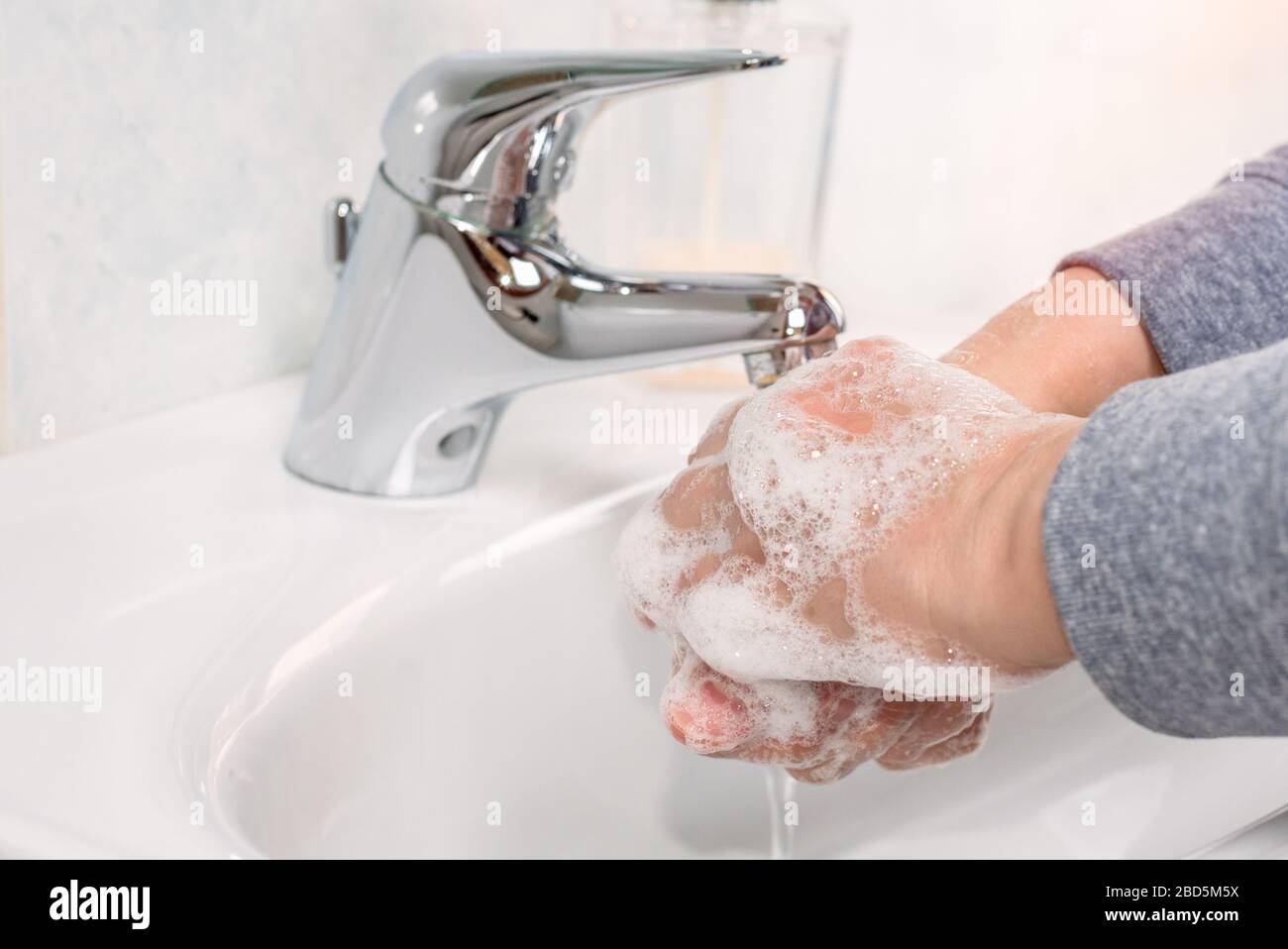 Donna che lava le mani con sapone. Prevenzione e igiene dell'epidemia di coronavirus. Foto Stock