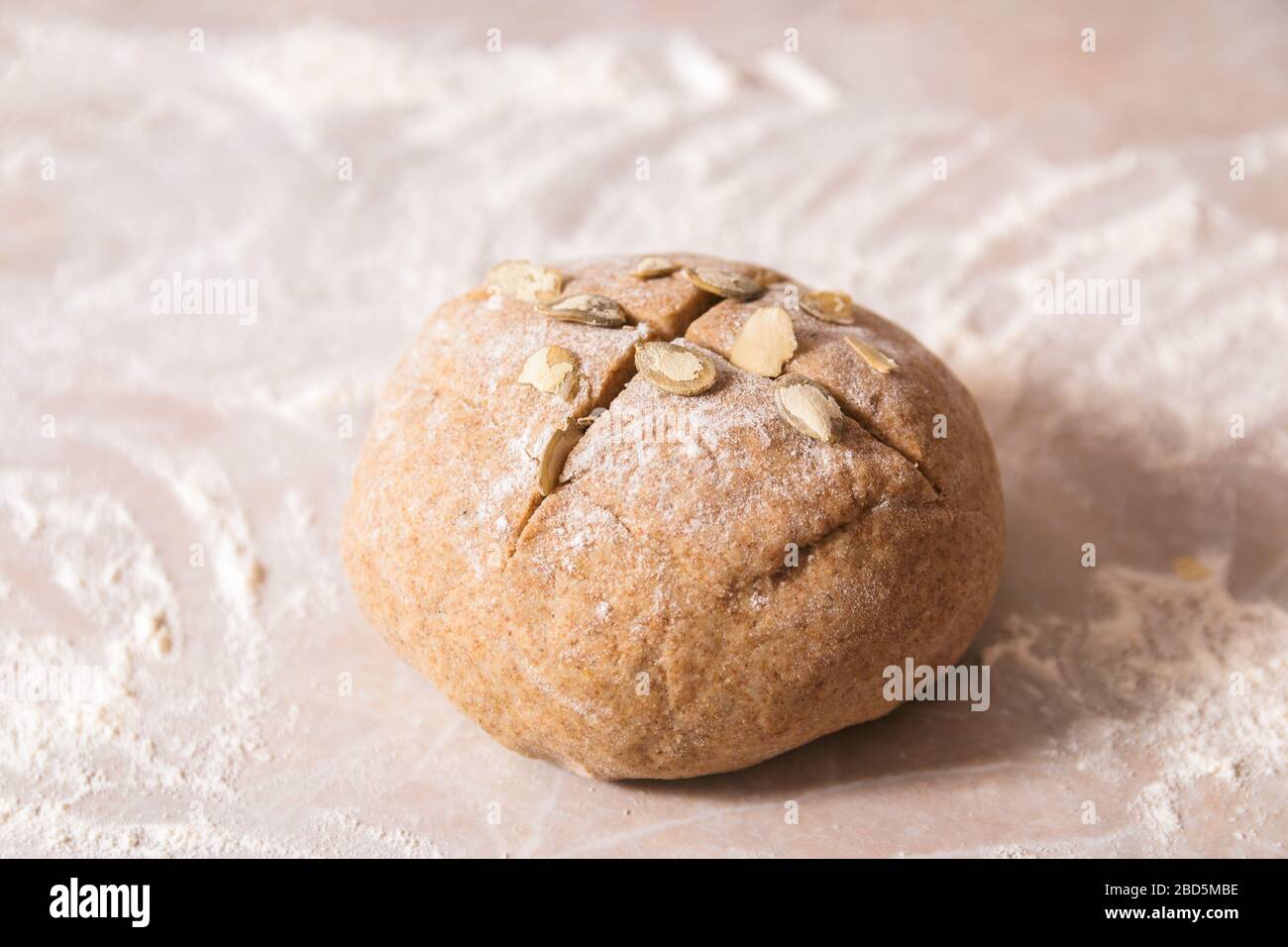 palla di pasta impastata da farina di segale su piano di marmo pronta per essere portata in forno Foto Stock
