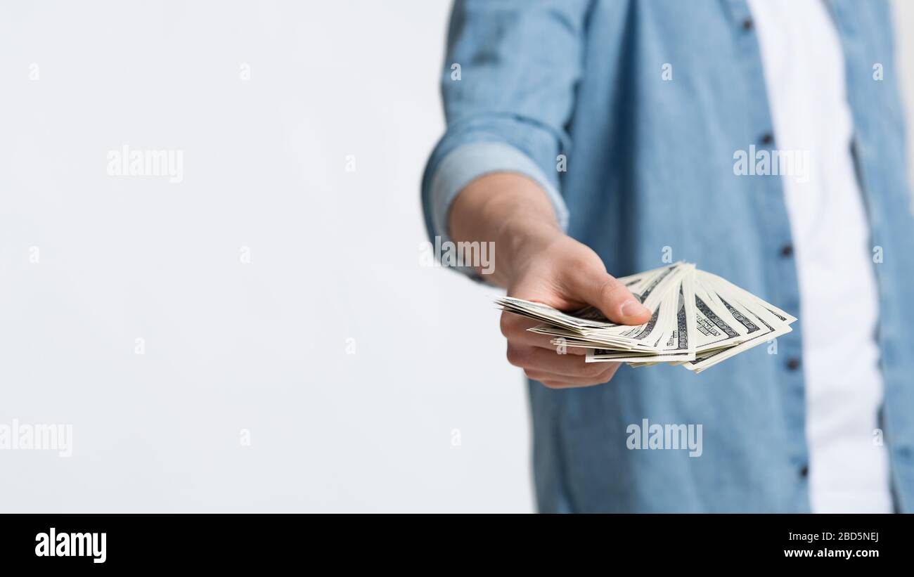 Un concetto di soldi molto. Dollari in mani di uomo Foto Stock