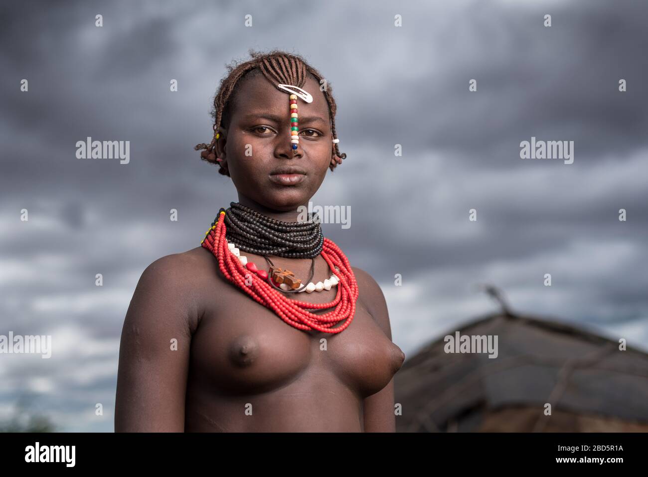 Una giovane donna non sposata è membro del gruppo etnico o della tribù di Dassanetch, Omorate, Etiopia meridionale. Foto Stock