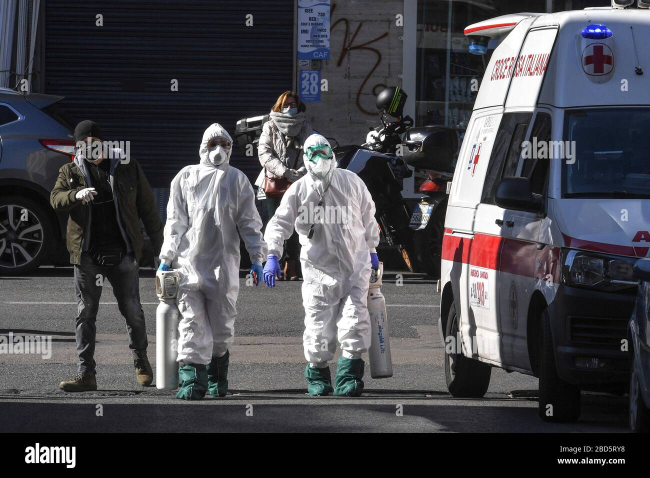 Napoli, Italia. 7 aprile 2020. I paramedici di emergenza che indossano tute di protezione chimica trasportano bombole di ossigeno per uso medico nel distretto di Fuorigrotta per i pazienti sospetti di infezione da coronavirus COVID-19. Credit: Independent Photo Agency Srl/Alamy Live News Foto Stock