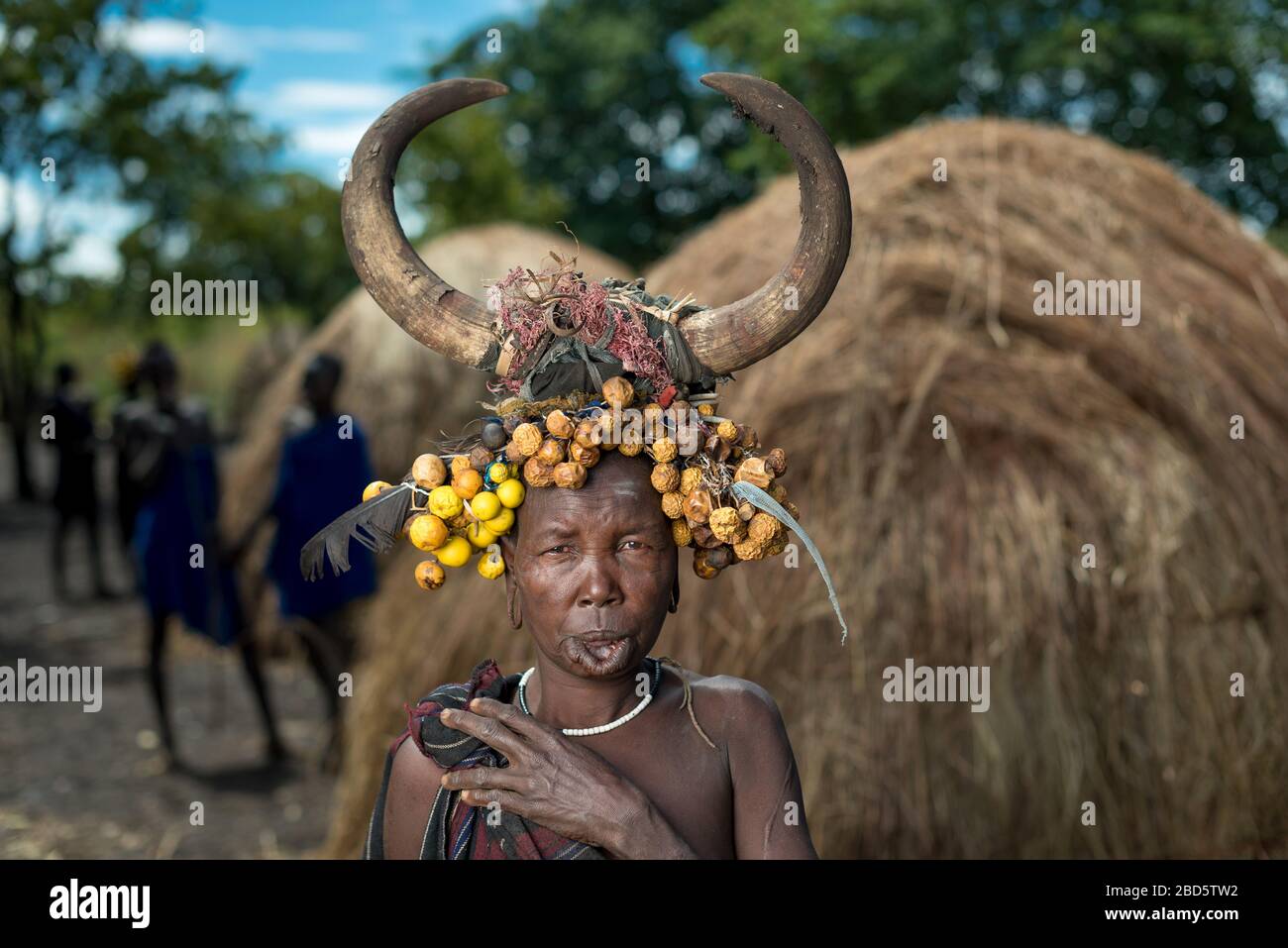 Con il suo piatto di labbra di argilla rimosso donna con frutta secca e corno di bestiame, tribù Mursi o gruppo etnico, Olikoru Village, Jenka, Etiopia. Foto Stock