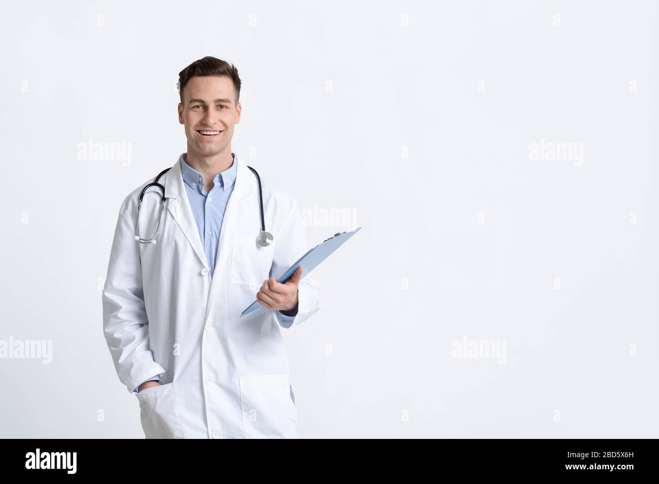 Medico sorridente in un cappotto bianco con compressa Foto Stock