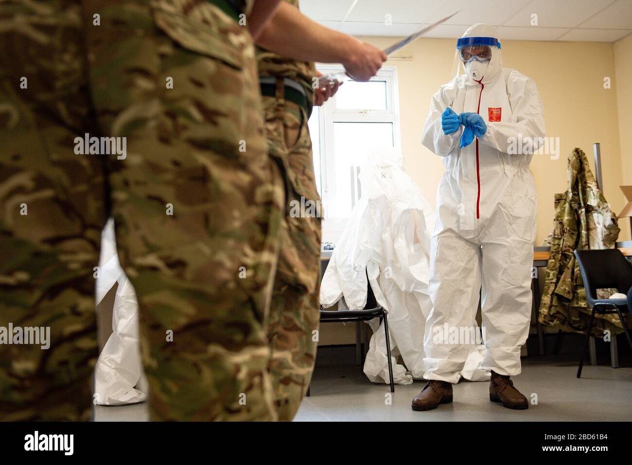 I membri dell'esercito britannico imparano come applicare i DPI durante l'addestramento per sostenere il Welsh Ambulance Service NHS Trust (WAST) nella battaglia contro COVID-19 al campo di addestramento di Sennybridge nel Galles centrale. Foto Stock