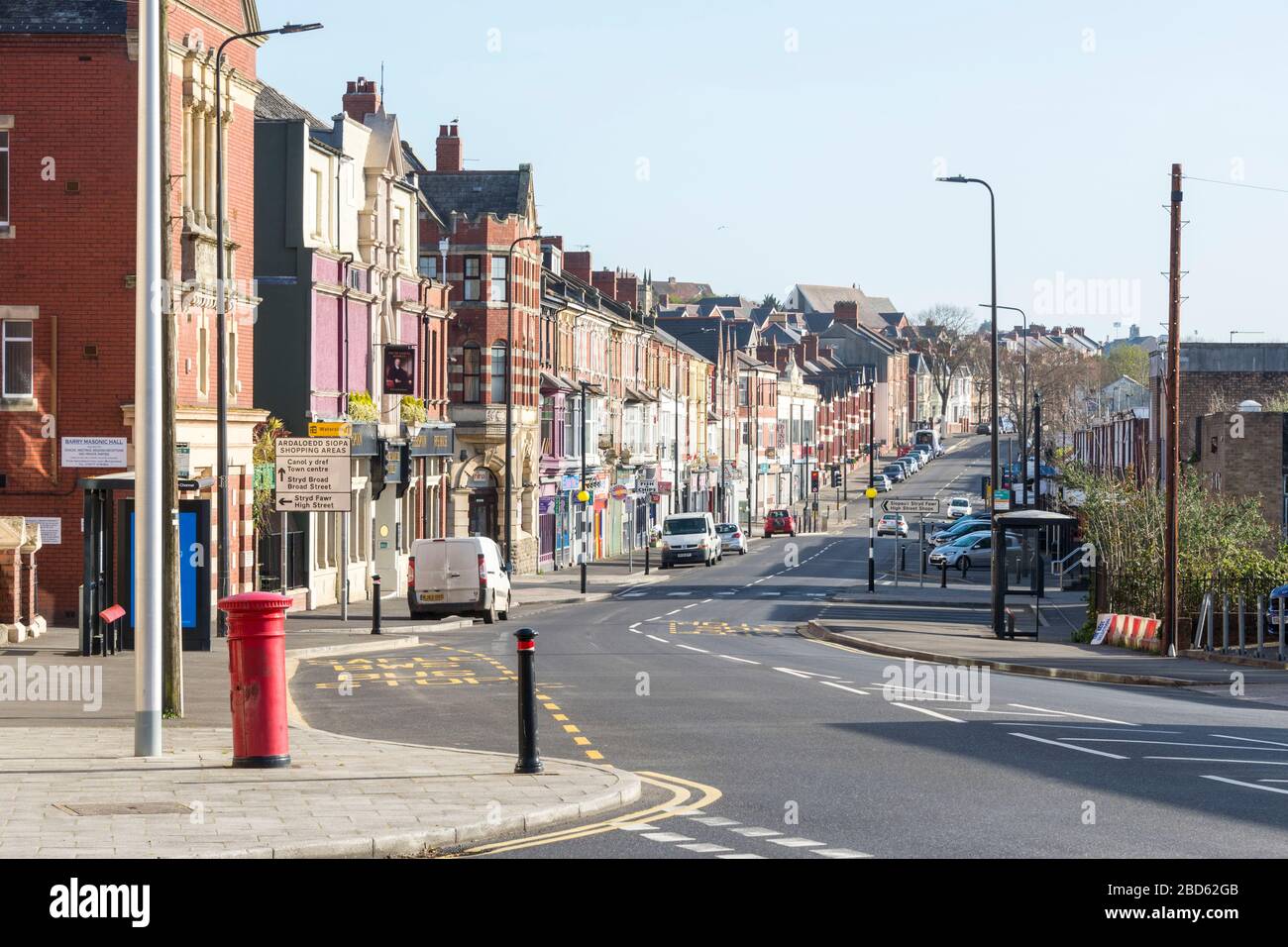 In una luminosa mattinata di sole nei giorni feriali all'ora di punta, Broad Street, una strada principale a Barry è praticamente deserta durante le crisi di coronavirus del Covid-19. Foto Stock