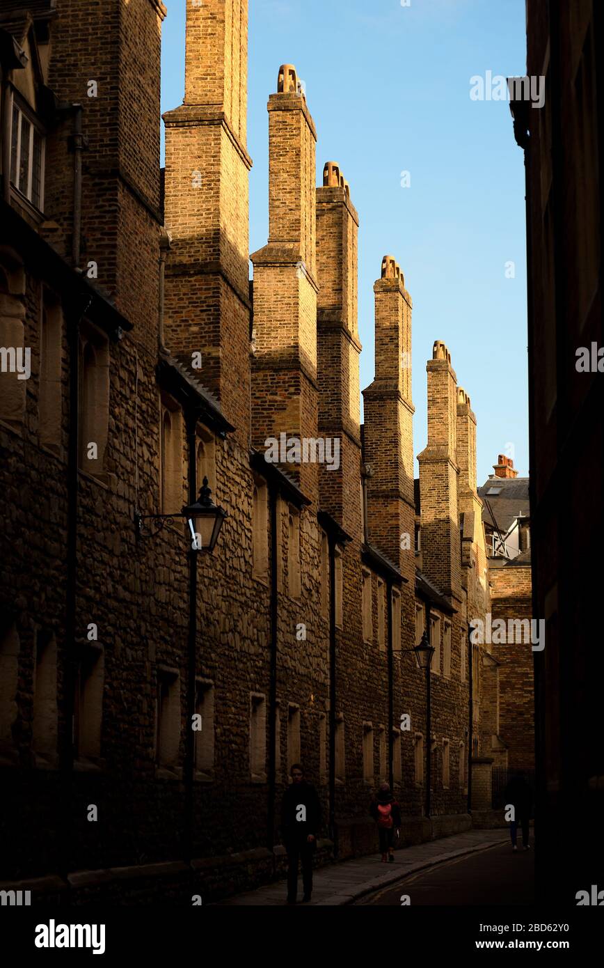 Una strada posteriore scura di Cambridge ha vecchie case tradizionali di pietra di Ketton ha file di torreggianti pile alte di camino. Foto Stock