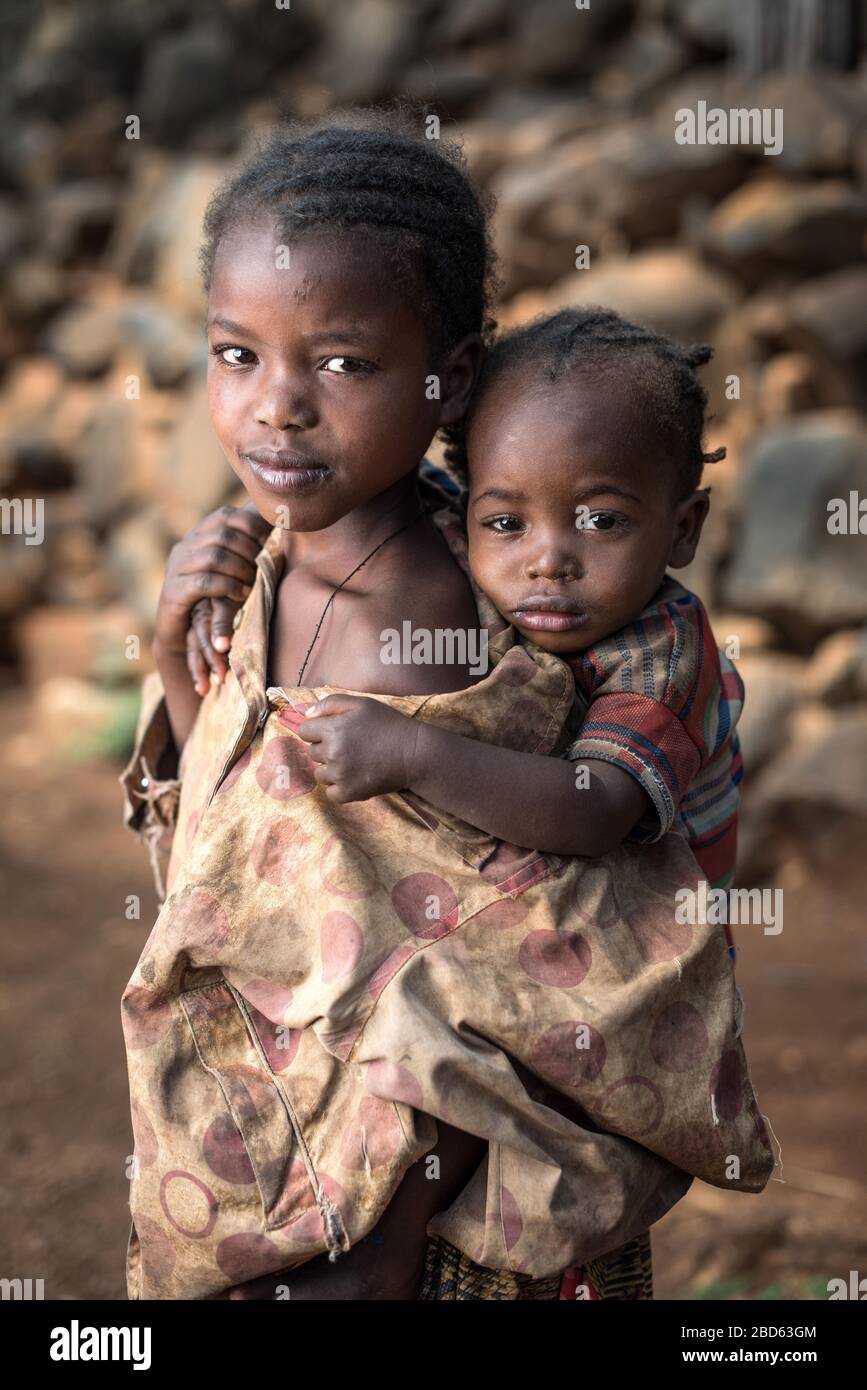 Il fratello maggiore porta la sorella minore, i membri del gruppo etnico o della tribù Konso, il villaggio di Gamole, Abra Minch, Etiopia. Foto Stock