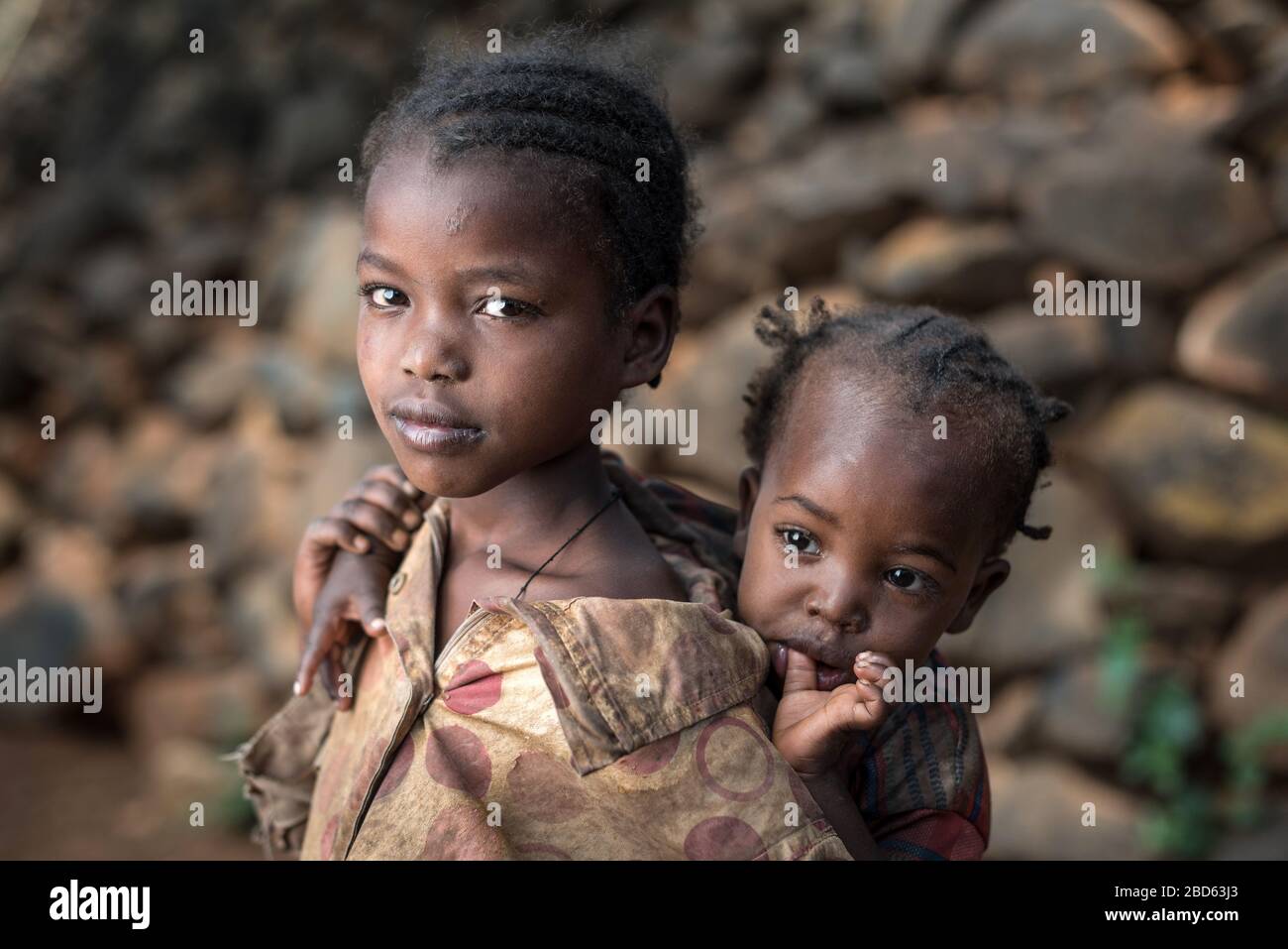 Il fratello maggiore porta la sorella minore, i membri del gruppo etnico o della tribù Konso, il villaggio di Gamole, Abra Minch, Etiopia. Foto Stock