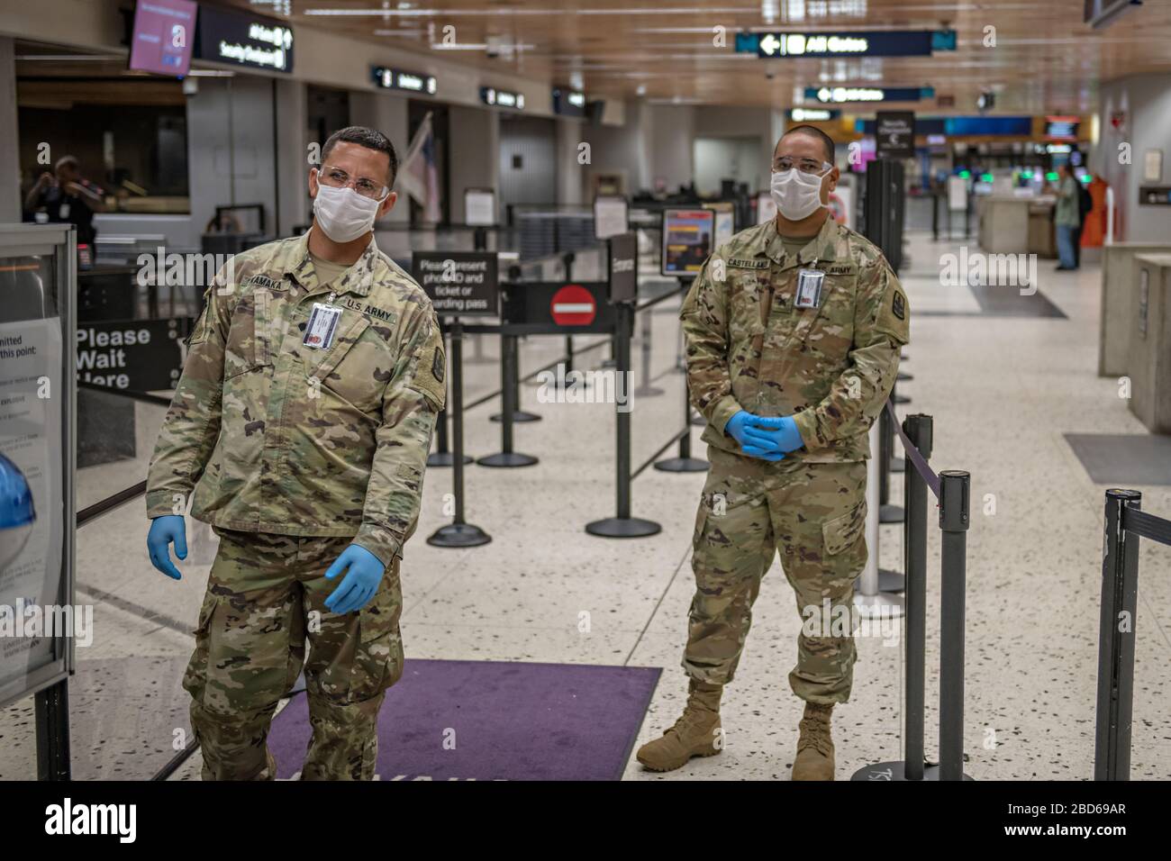 I soldati della Guardia Nazionale dell'Esercito delle Hawaii aspettano di schermare i passeggeri in partenza all'Aeroporto Internazionale Daniel K. Inouye il 6 aprile 2020 a Honolulu, Hawaii. I soldati assistono il personale dei pompieri dell'aeroporto con lo screening del 100% dei viaggiatori in arrivo e in partenza, per includere i viaggi tra le isole. Foto Stock