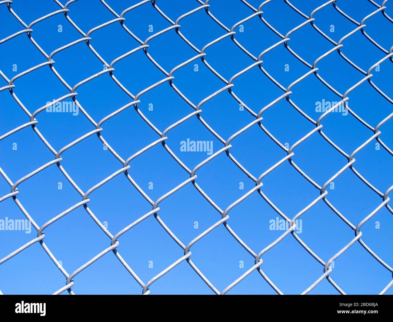 Catena maglia recinzione ambientato contro un cielo blu Foto Stock