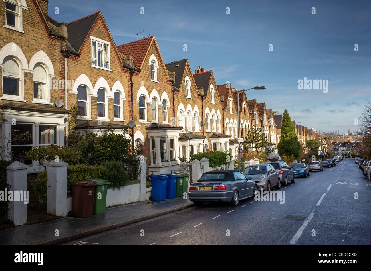 Una strada di tipiche case britanniche con parcheggio sulla strada Foto Stock