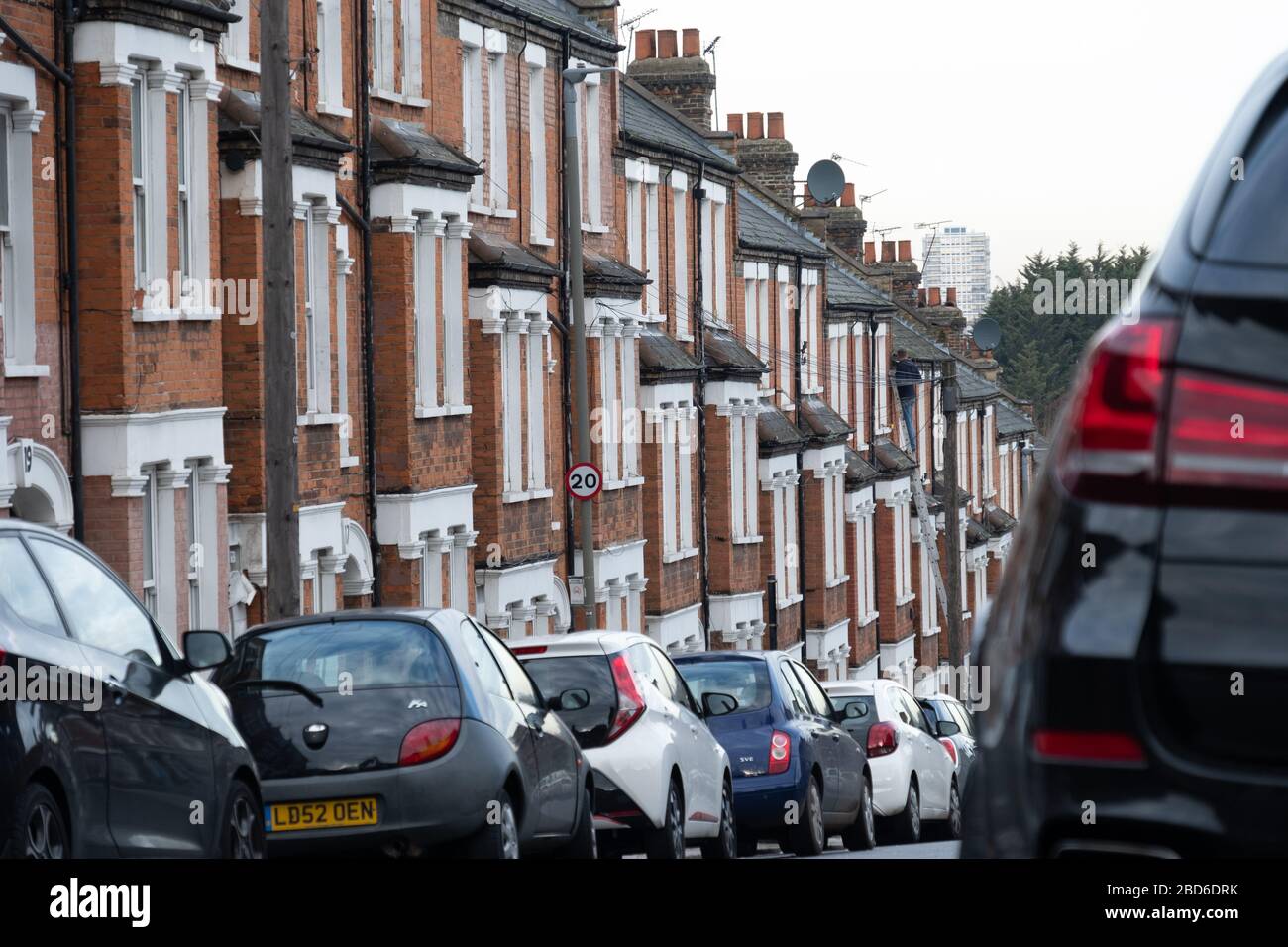 Una strada di tipiche case britanniche con parcheggio sulla strada Foto Stock