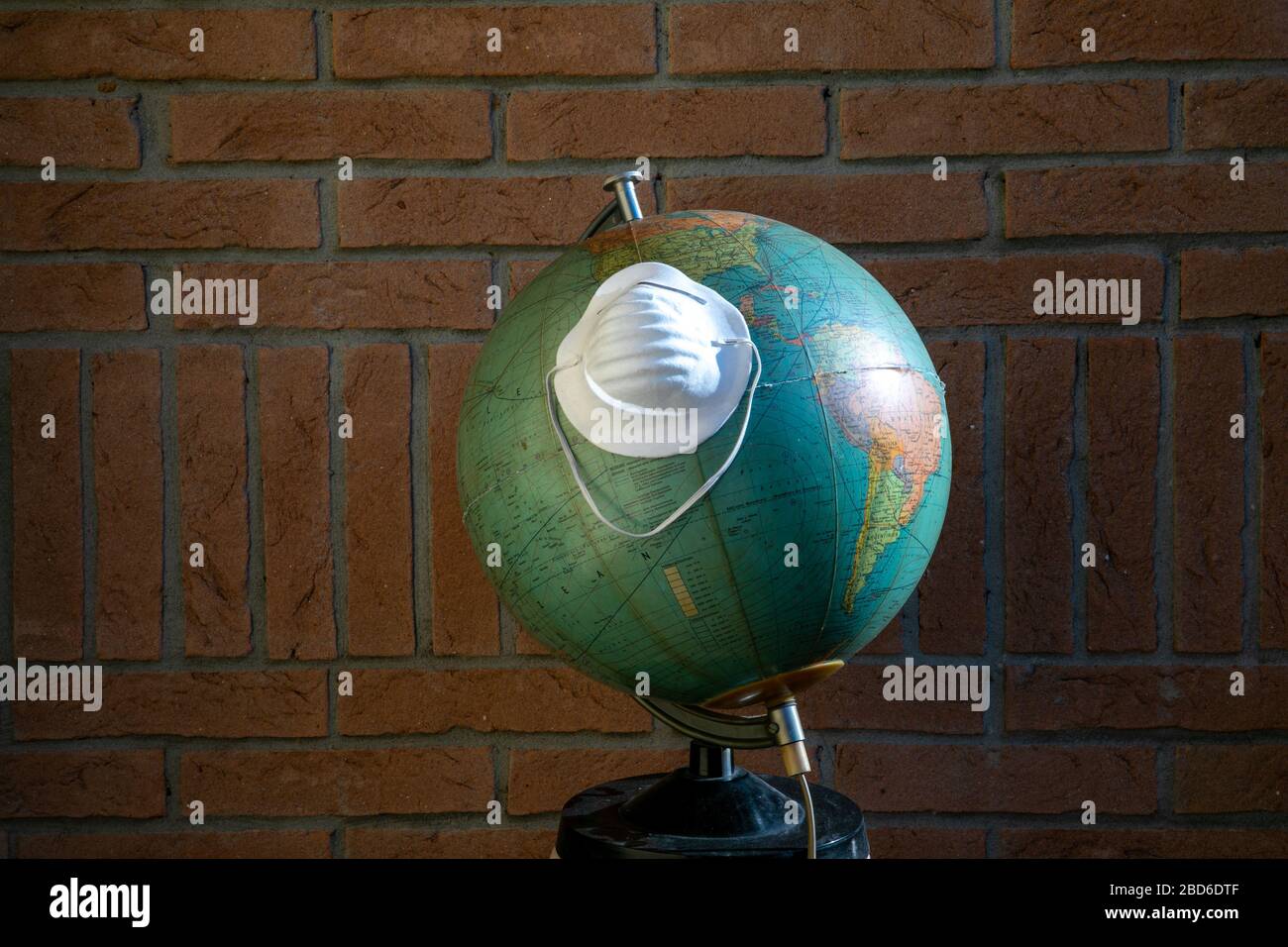 terra globo con maschera di protezione contro il coronavirus Foto Stock