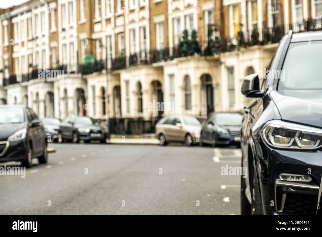 Una strada di tipiche case britanniche con parcheggio sulla strada Foto Stock