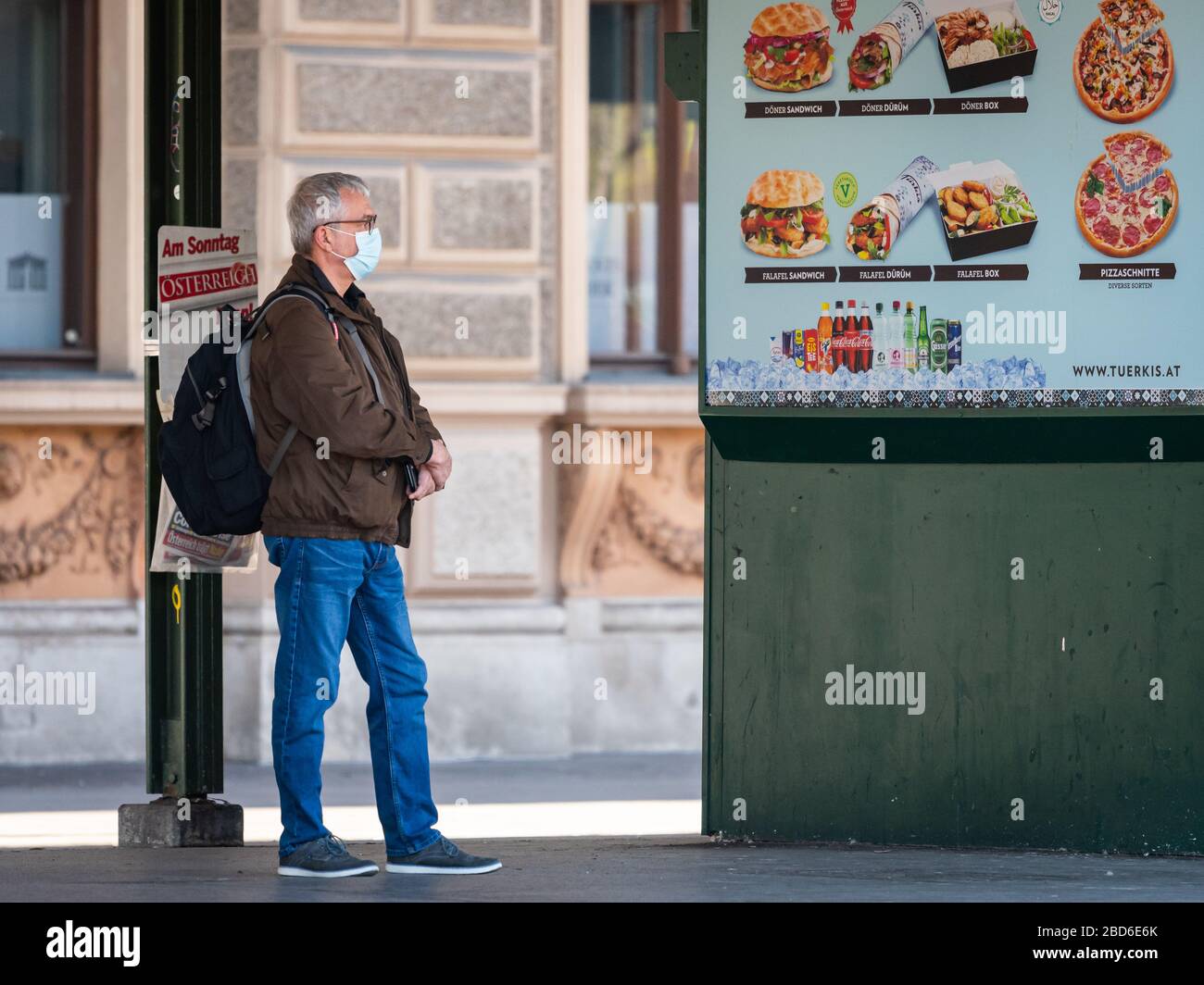 Vienna, Austria - 04 aprile 2020: Uomo che indossa una maschera per strada, protezione contro l'infezione da virus corona, giorno di sole in primavera Foto Stock