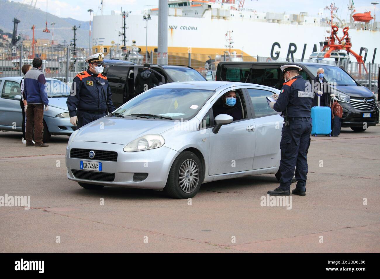 Un membro della famiglia di un italiano di ritorno dalla Tunisia per l'emergenza dal covid-19 sta andando lasciare il porto commerciale dopo essere stato controllato Foto Stock