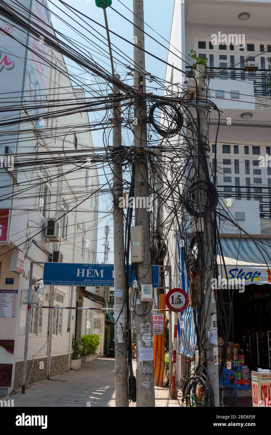 Groviglio di cavi e fili sospesi lungo la strada nella città di ho Chi Minh (precedentemente Saigon) Vietnam del Sud, Asia sudorientale Foto Stock